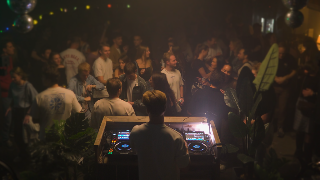 Frasjan performing a live DJ set at Shake je Container, mixing energetic Italo House tracks as the crowd dances and enjoys the lively outdoor vibe.