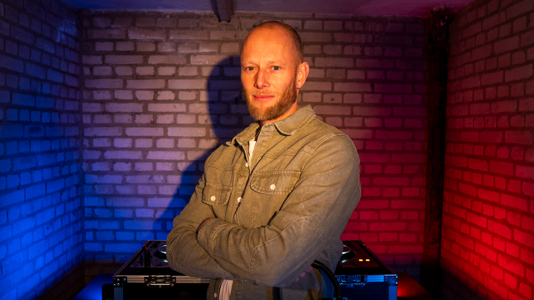 REVLIN performing a house DJ set during Shelter Sessions, focused behind the decks while mixing groovy house tracks inside the bunker recording space.